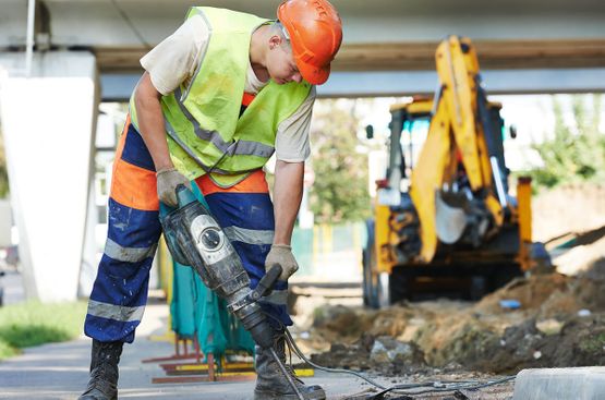 worker using a power tool to carry out ground repairs
