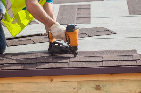 roofer using a nail gun to fit roof